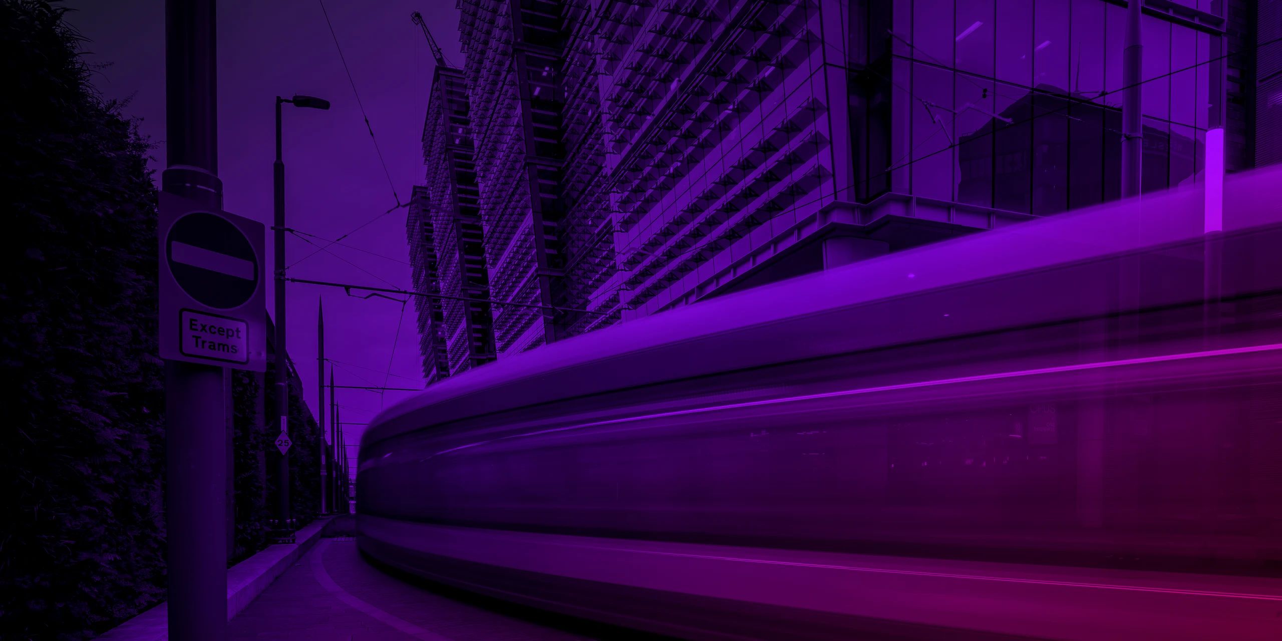 A West Midlands Metro tram passing glass office buildings in Birmingham