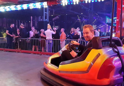 Alex Ashman, director of magic42, in a bumper car with a huge grin on his face as he mingles with his eCommerce development team at magic42